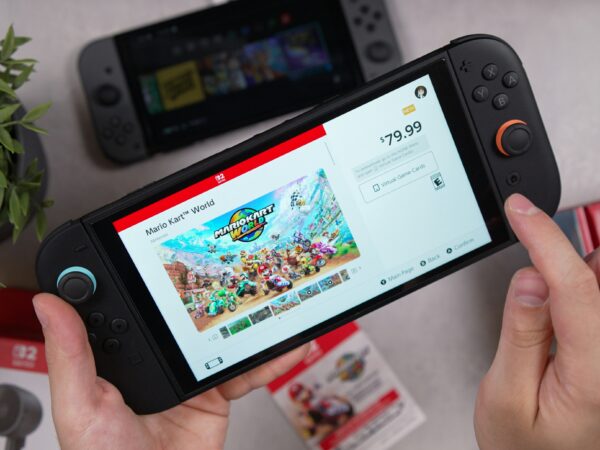 Nintendo Switch 2 trzymany w dłoniach z otwartą stroną Mario Kart World w sklepie cyfrowym